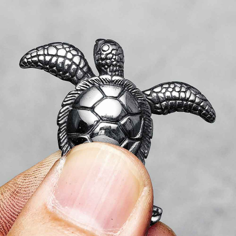 Man pinching stainless steel Turtle Pendant 