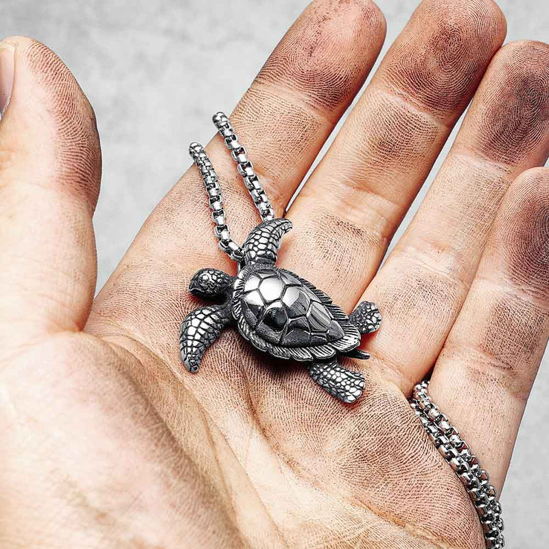 Man holding Hawksbill Turtle Necklace in palm
