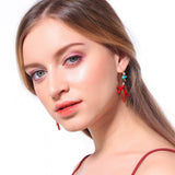 Model wears Red Enamel Drop Earrings in Coral design 