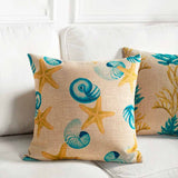 sea star and nautilus shell cushion on white sofa
