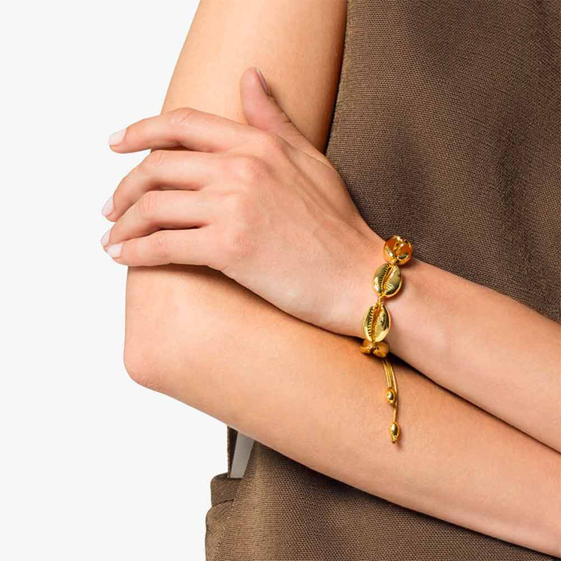 Gold Cowrie Bracelet on women's wrist