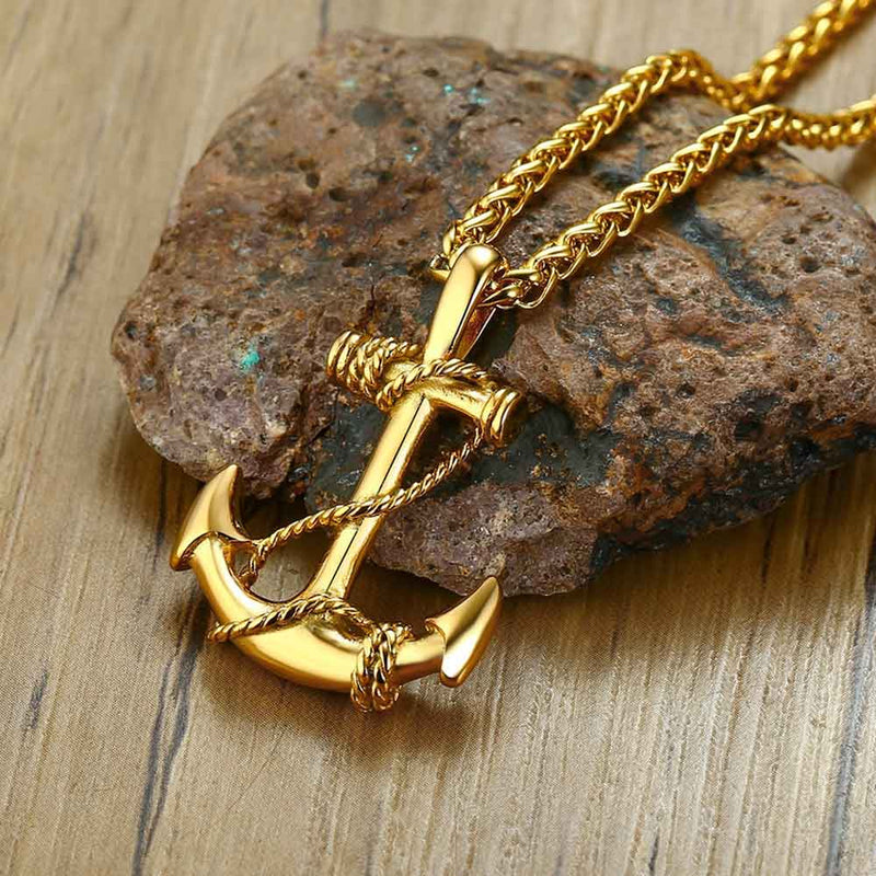 Front view of a Gold Anchor Pendant on rock display