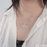 Woman model wearing a sailboat necklace