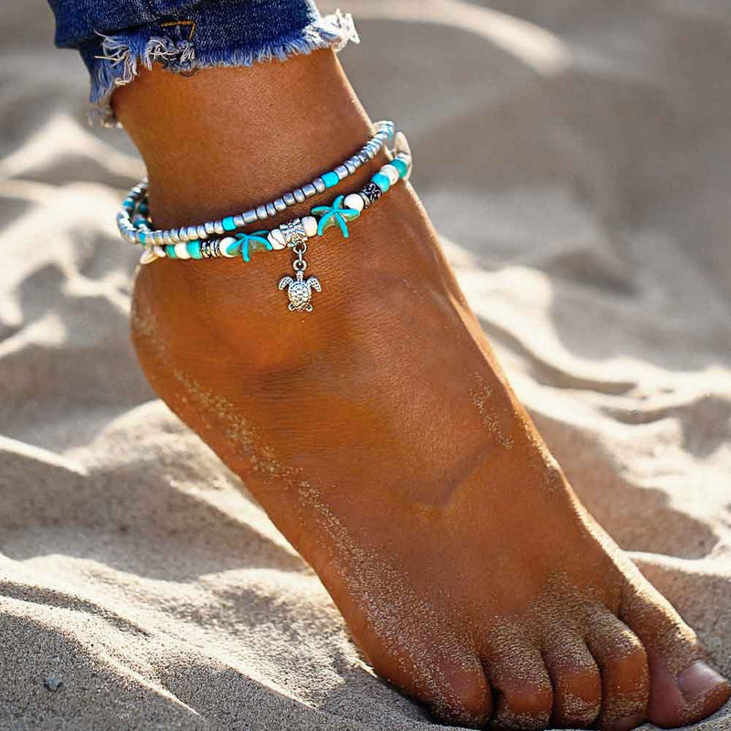Woman wearing a Starfish Anklet with Turtle Charm on the beach